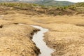 Photo in the area of Ã¢â¬â¹Ã¢â¬â¹muddy volcanoes in Buzau, Romania, where gray lava can be seen flowing on the cracked volcanic soil